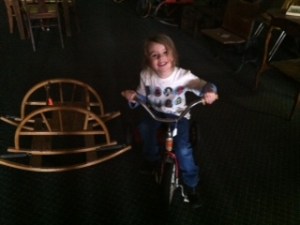 Riding a really old tricycle at the thrift store...wearing her Star Wars shirt, of course.